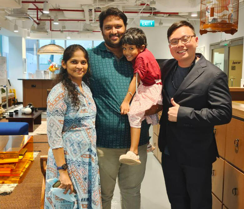 Alvin smiling with a client family after meeting in person.